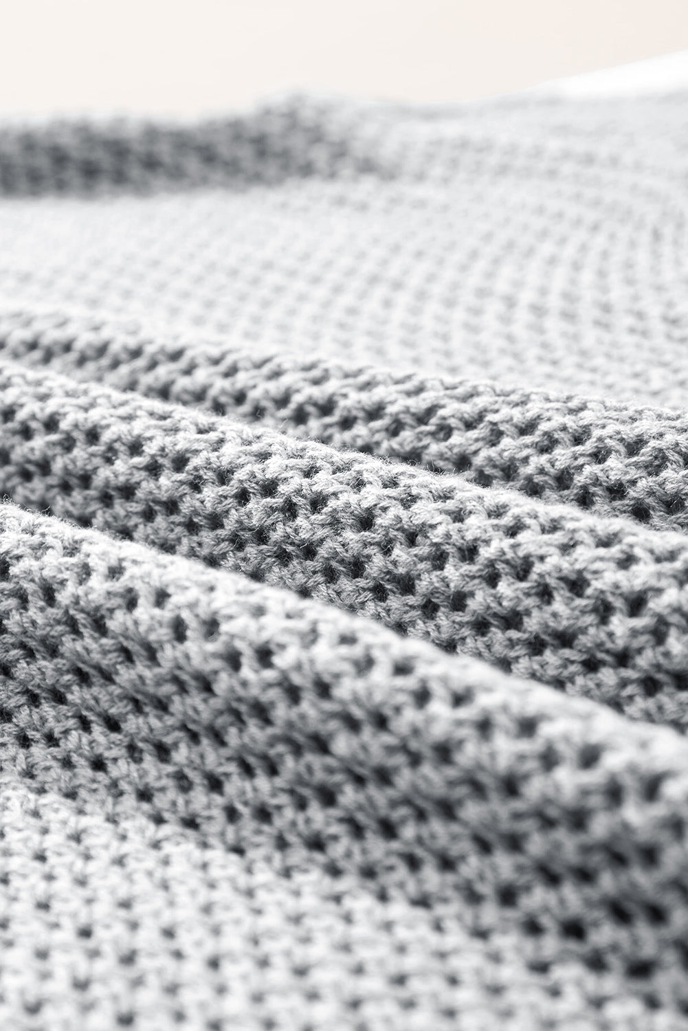 Hellgrauer Strickpullover mit großer Blume und überschnittener Schulter