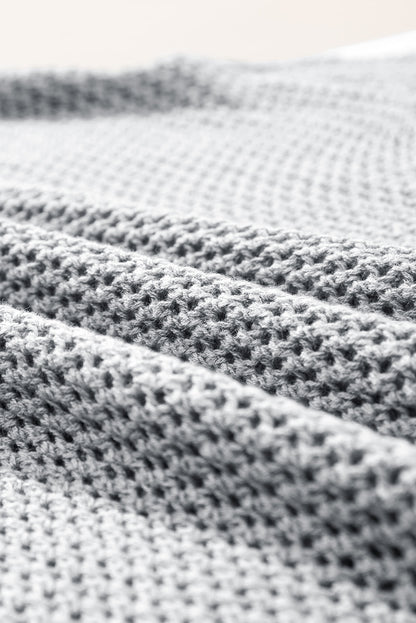 Hellgrauer Strickpullover mit großer Blume und überschnittener Schulter