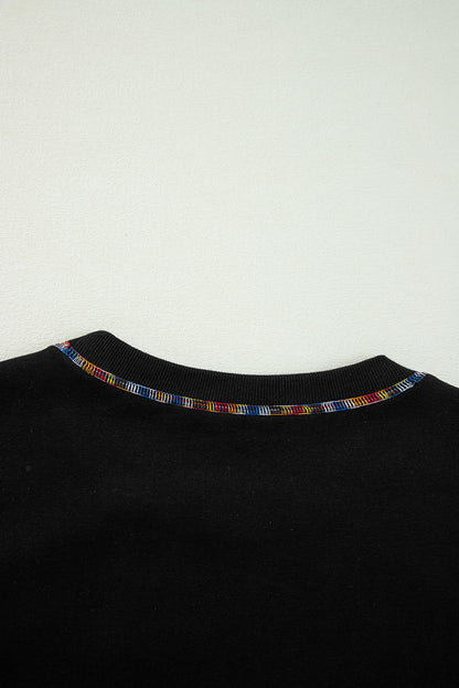 Schwarzes Pullover-Sweatshirt mit überschnittener Schulter und kontrastierendem Regenbogenbesatz