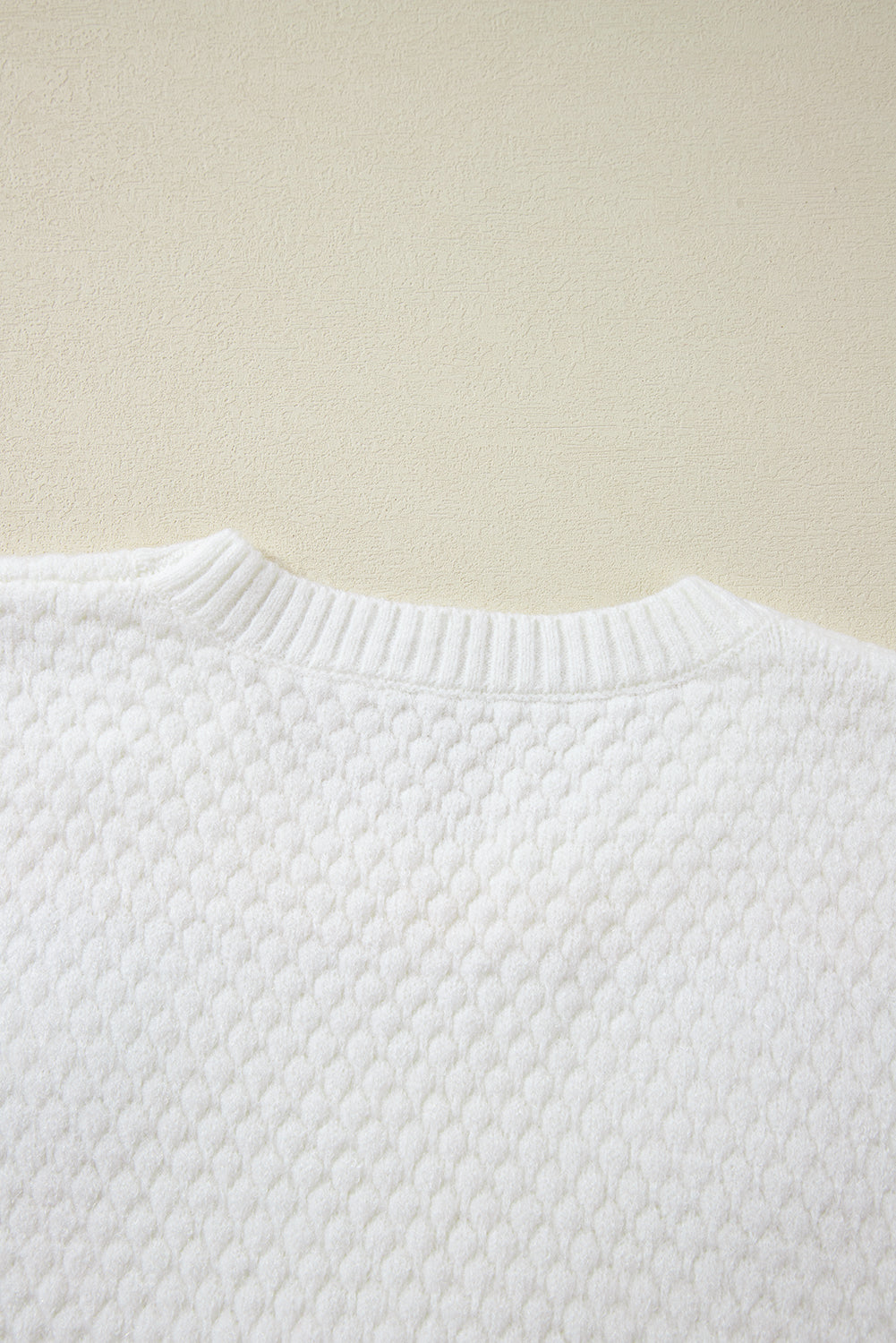 Weißer Strickpullover mit bunter Blumenapplikation