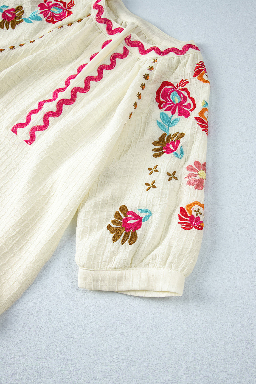 Beigefarbene Bluse mit floraler Stickerei und strukturierten Puffärmeln im Ricrac-Stil