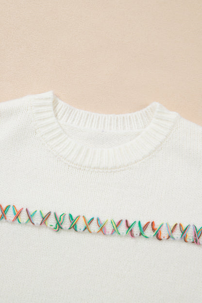 Weißer Pullover mit bunten Kreuzstichen und überschnittenen Schultern