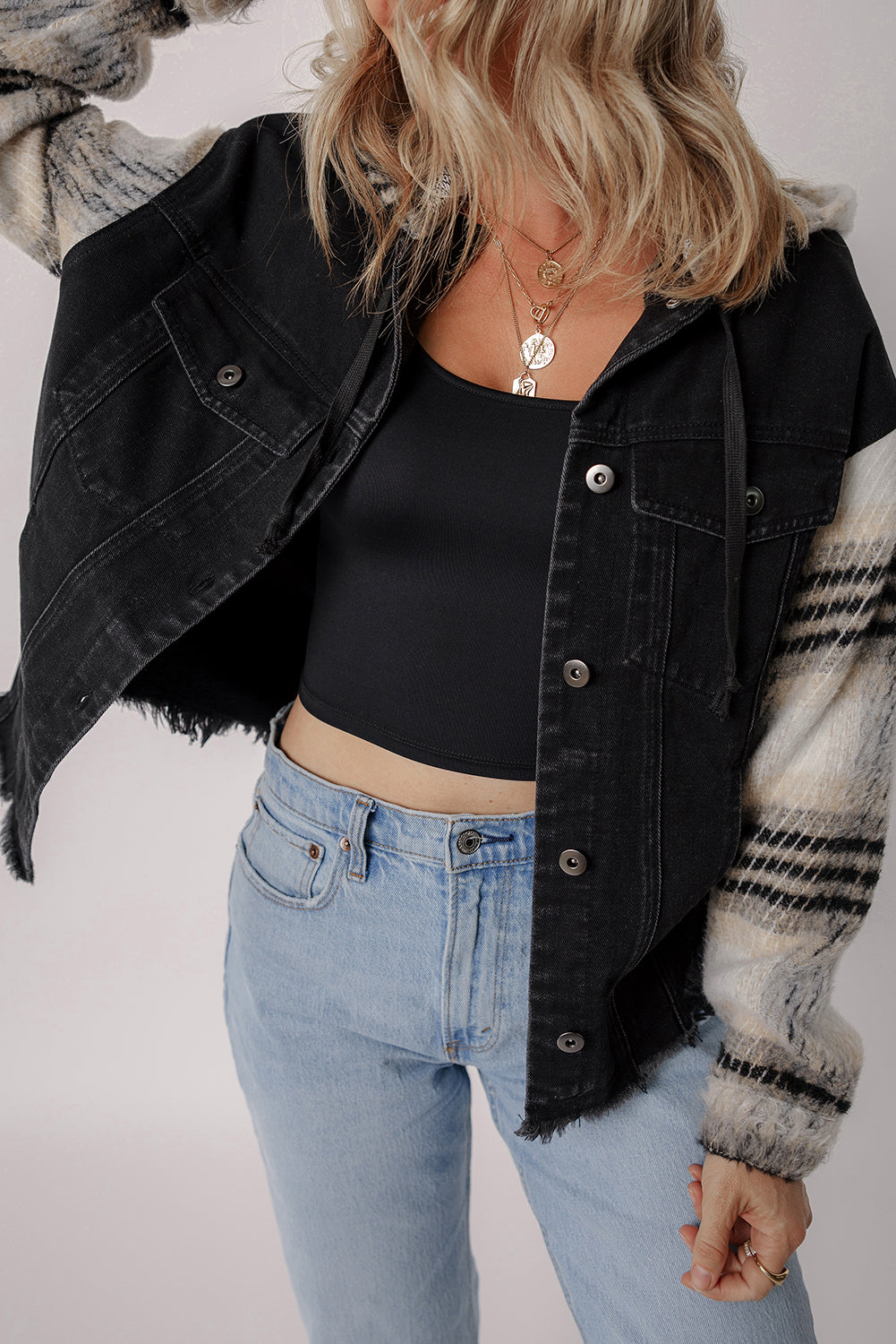 Schwarze Jeansjacke mit Kapuze und karierten Ärmeln und ausgefranstem Saum