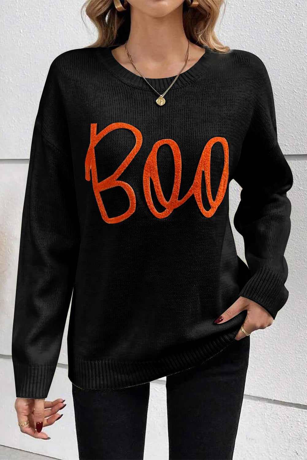Schwarzer Pullover mit überschnittener Schulter und geripptem Rand und Boo-Strickmuster