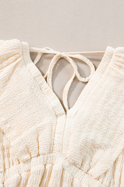 Beiges strukturiertes Minikleid mit tiefem V-Ausschnitt und Cut-Out auf der Rückseite