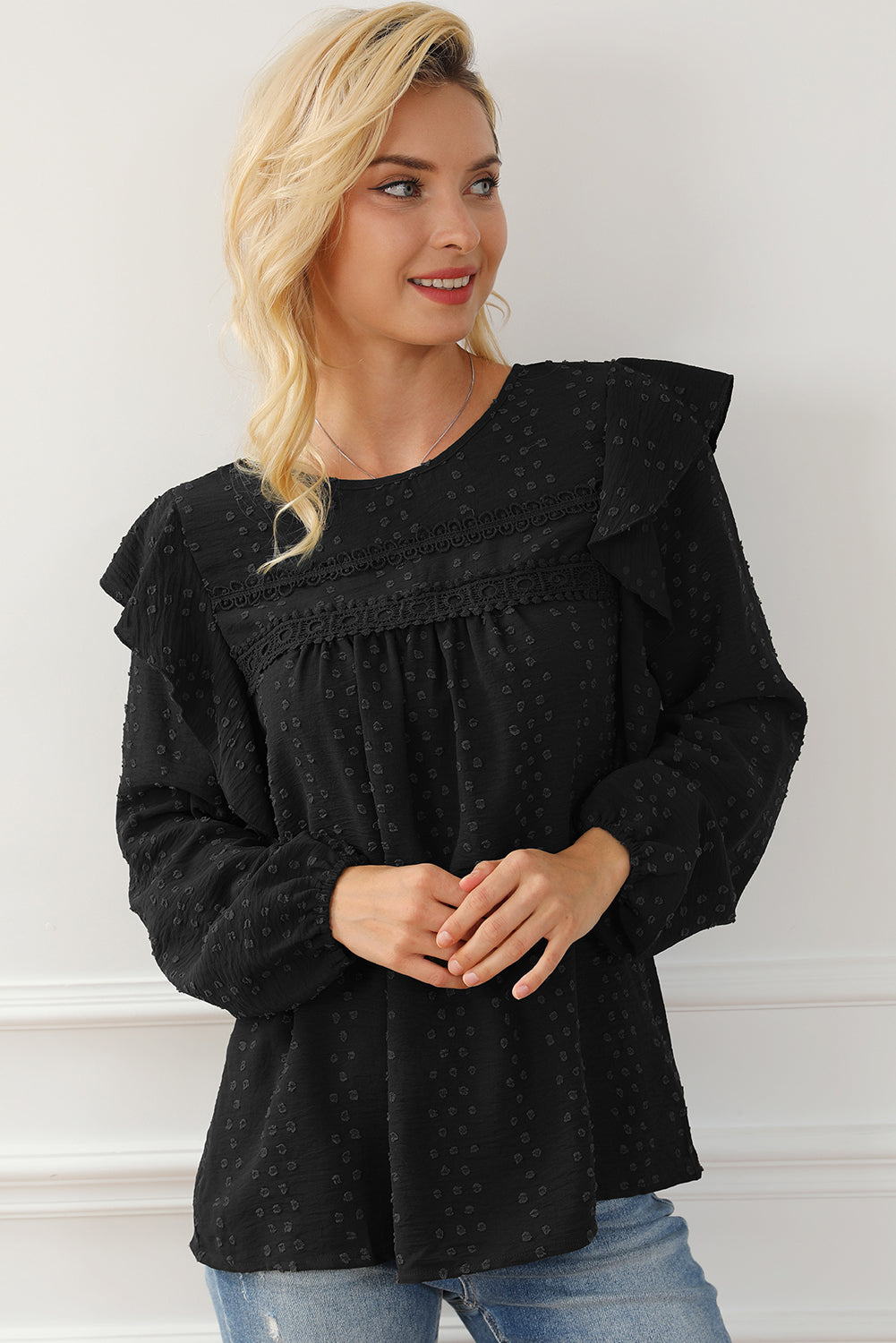 Schwarze Bluse mit langen Ärmeln und Ösen an der Schulter aus Spitze und Rüschen