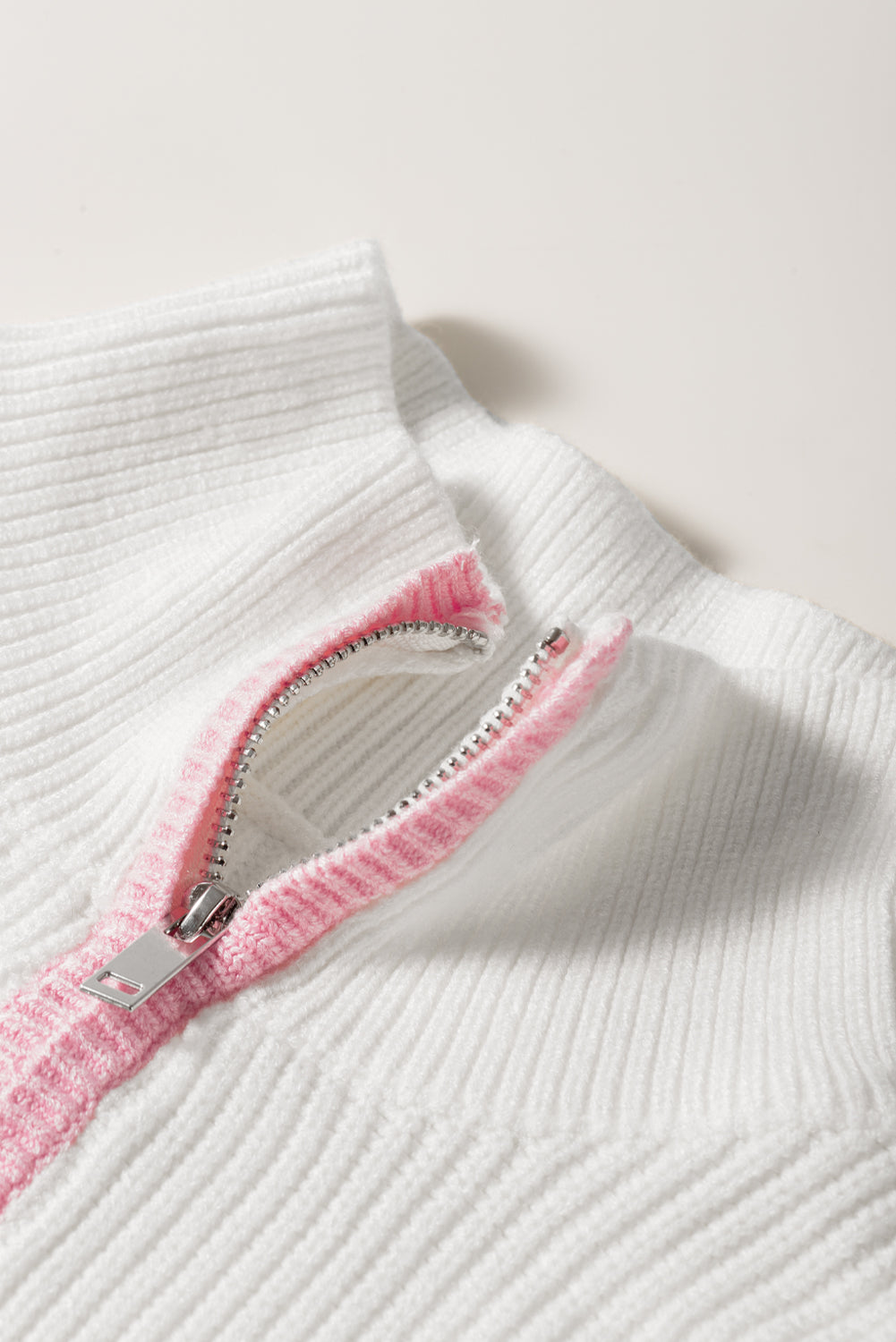 Weißer Pullover mit Viertelreißverschluss und überschnittener Schulterpartie mit buntem Rand