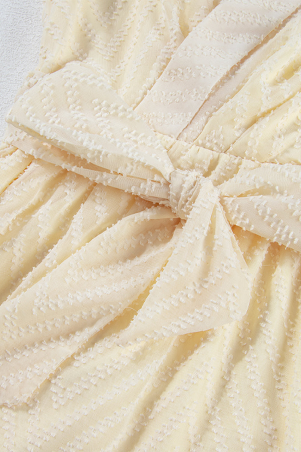 Aprikosenfarbenes Minikleid mit V-Ausschnitt, transparenten Puffärmeln und Knoten