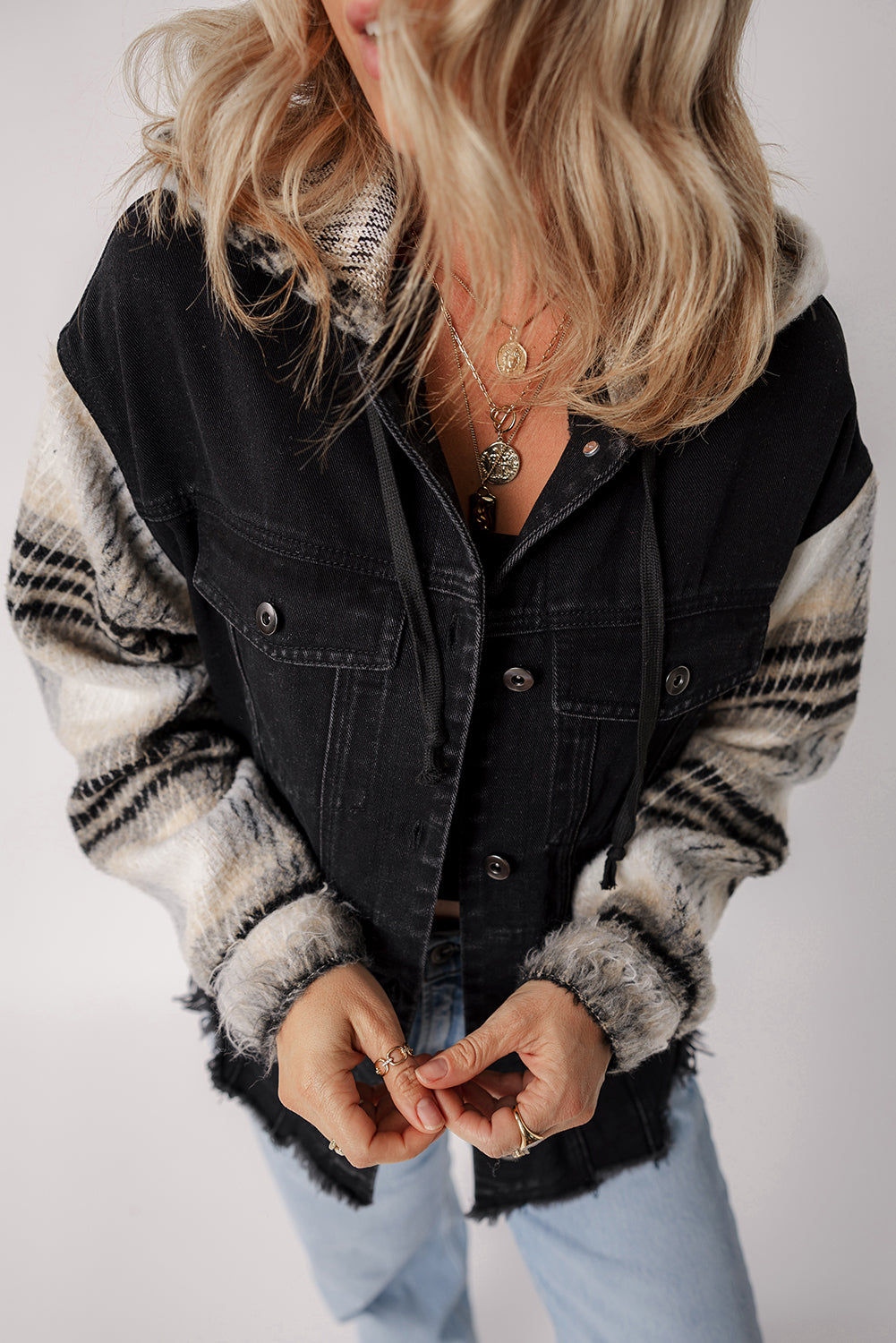Schwarze Jeansjacke mit Kapuze und karierten Ärmeln und ausgefranstem Saum