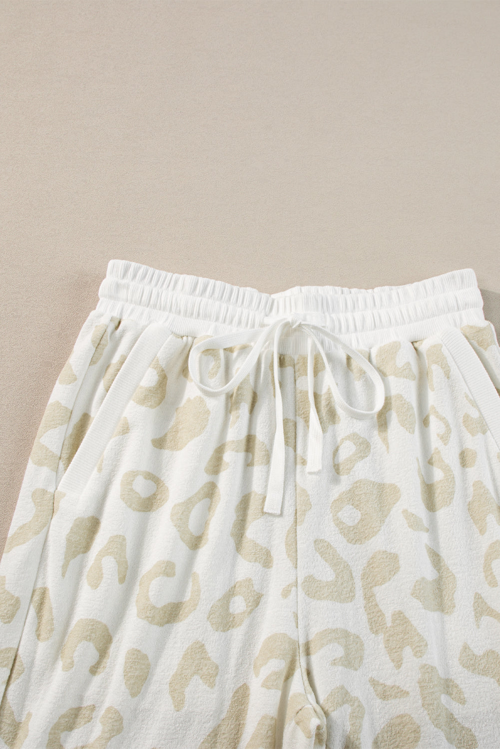 Lounge-Set aus weißem Pullover mit Leopardenmuster und Hose mit Kordelzug