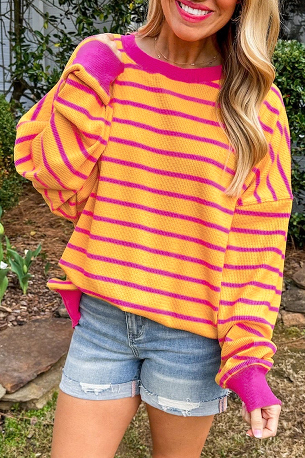 Orangefarbener Pullover mit Streifenbesatz, Rundhalsausschnitt und überschnittener Schulter