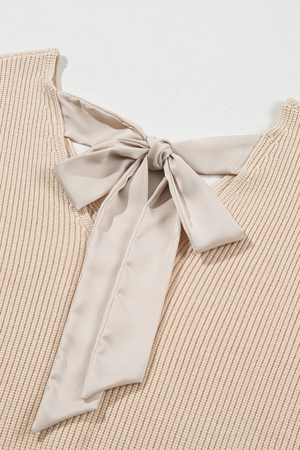 Aprikosenfarbener Pullover mit Laternenärmeln und V-Ausschnitt und Knoten hinten