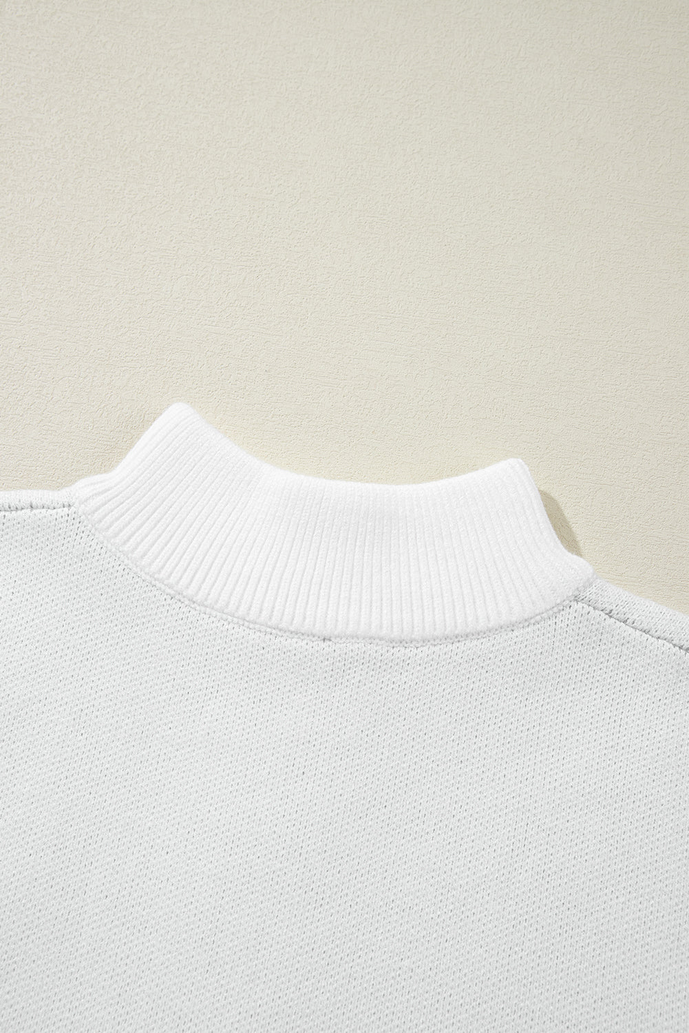 Weißer Pullover mit Stehkragen und halblangem Reißverschluss und Blumenmuster