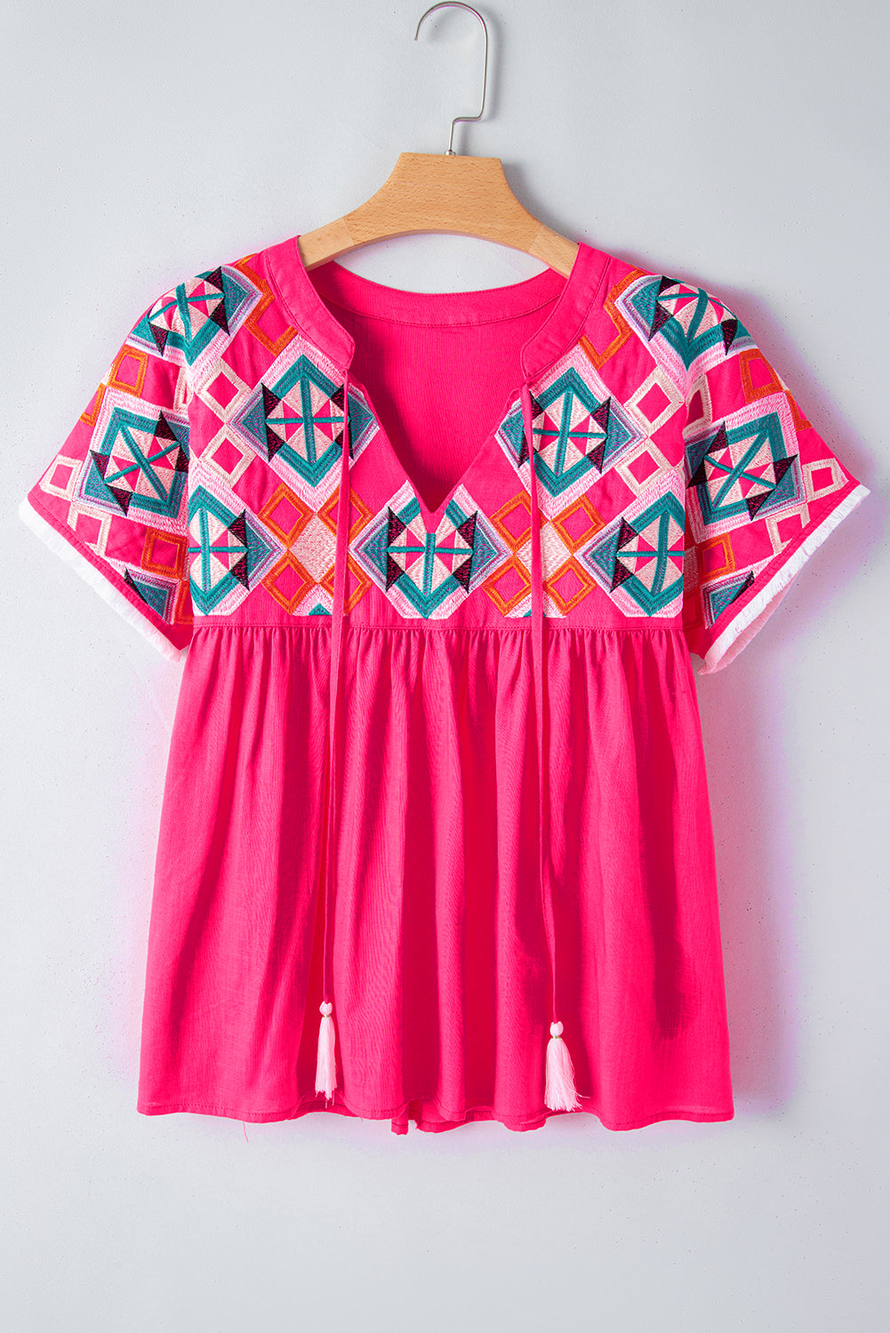 Erdbeerrosa Bluse mit V-Ausschnitt und geometrischer Stickerei, Quaste und Schleife