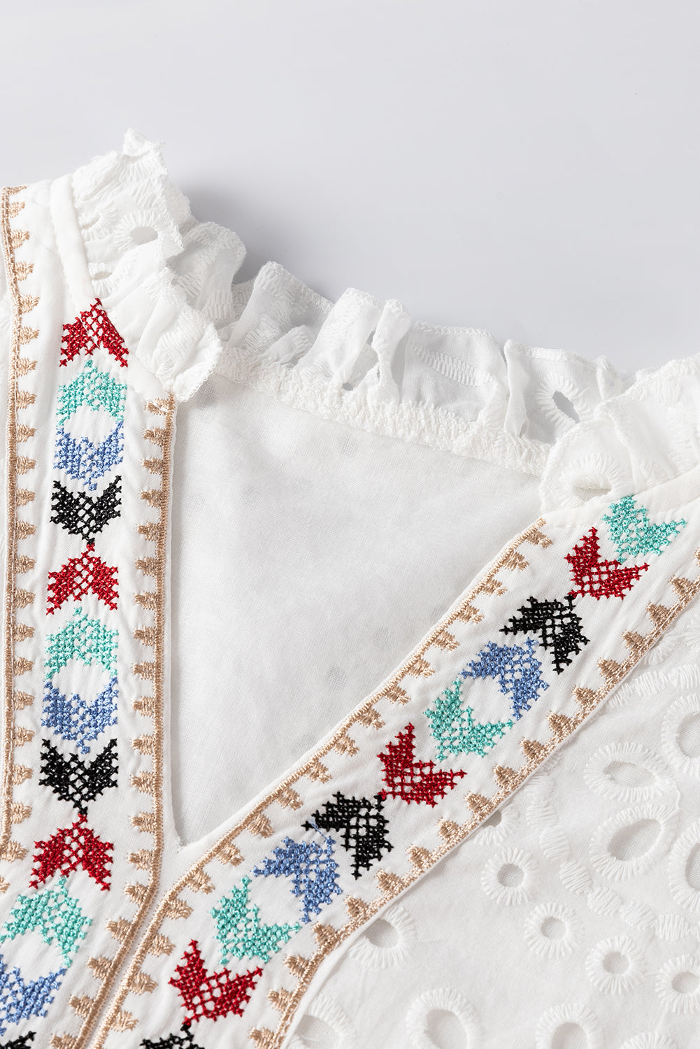 Weiße Bluse mit geometrischer Stickerei und Aussparung
