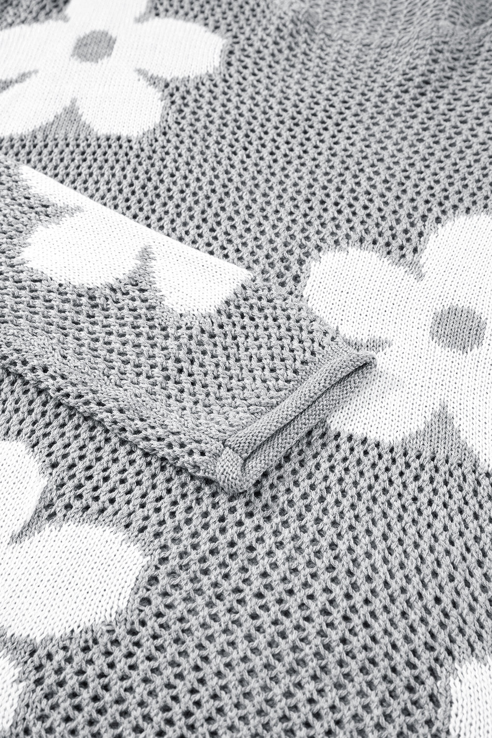Hellgrauer Strickpullover mit großer Blume und überschnittener Schulter