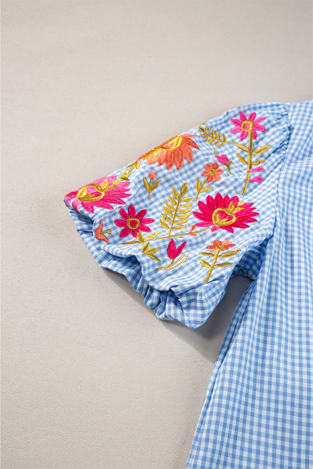Hellblaue Bluse mit Puffärmeln und Blumenstickerei im Gingham-Stil