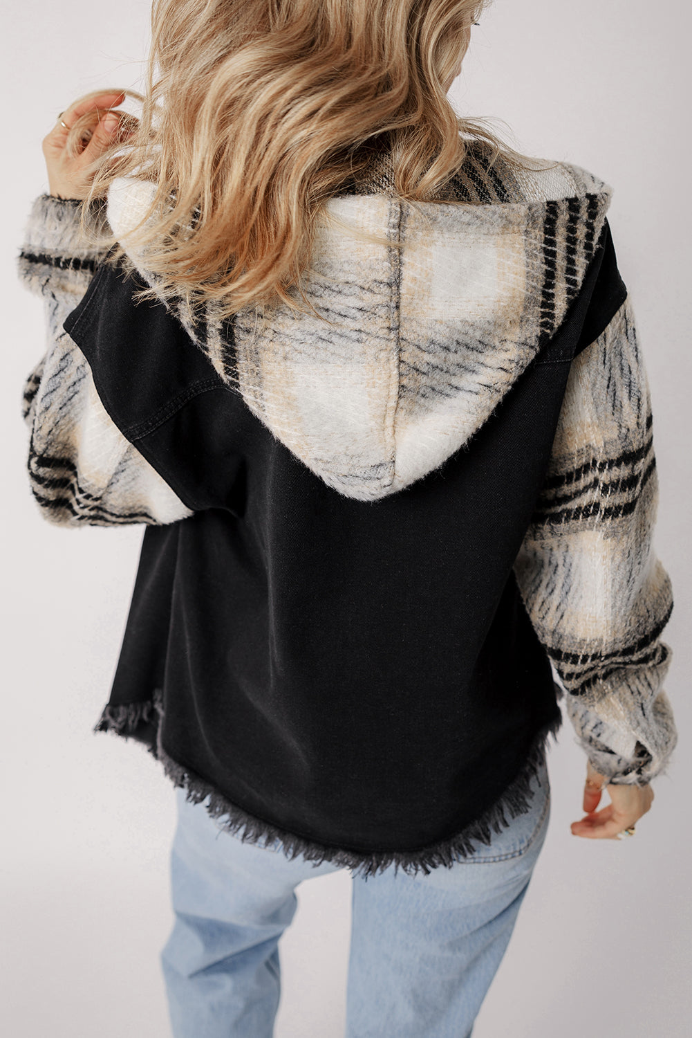 Schwarze Jeansjacke mit Kapuze und karierten Ärmeln und ausgefranstem Saum