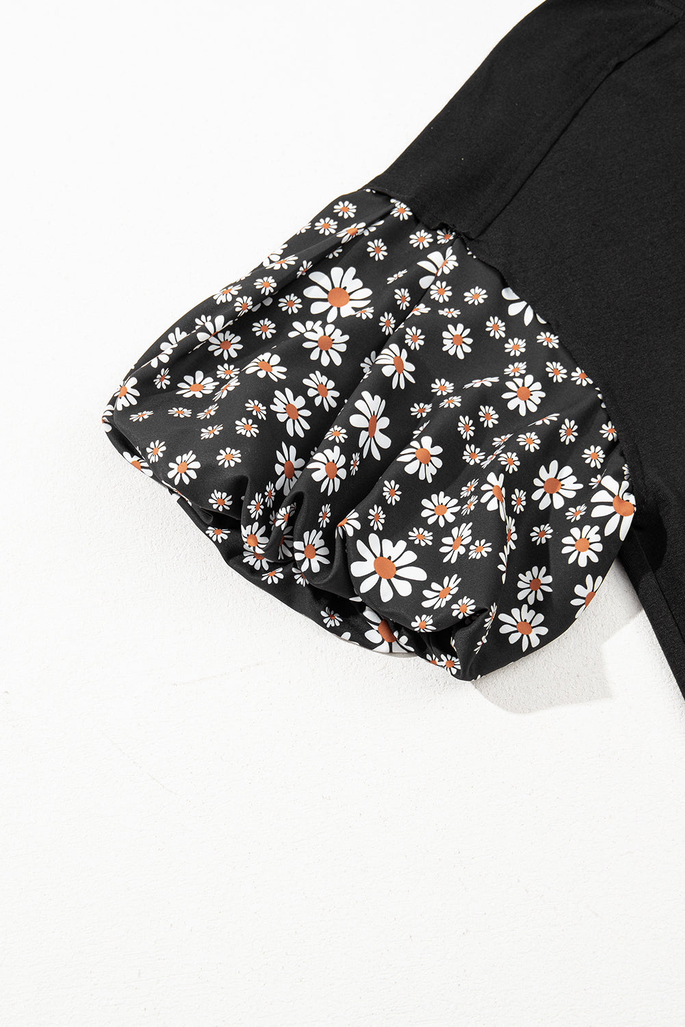 Schwarzes Oversize-Oberteil mit kontrastierendem Blumenmuster und Puffärmeln