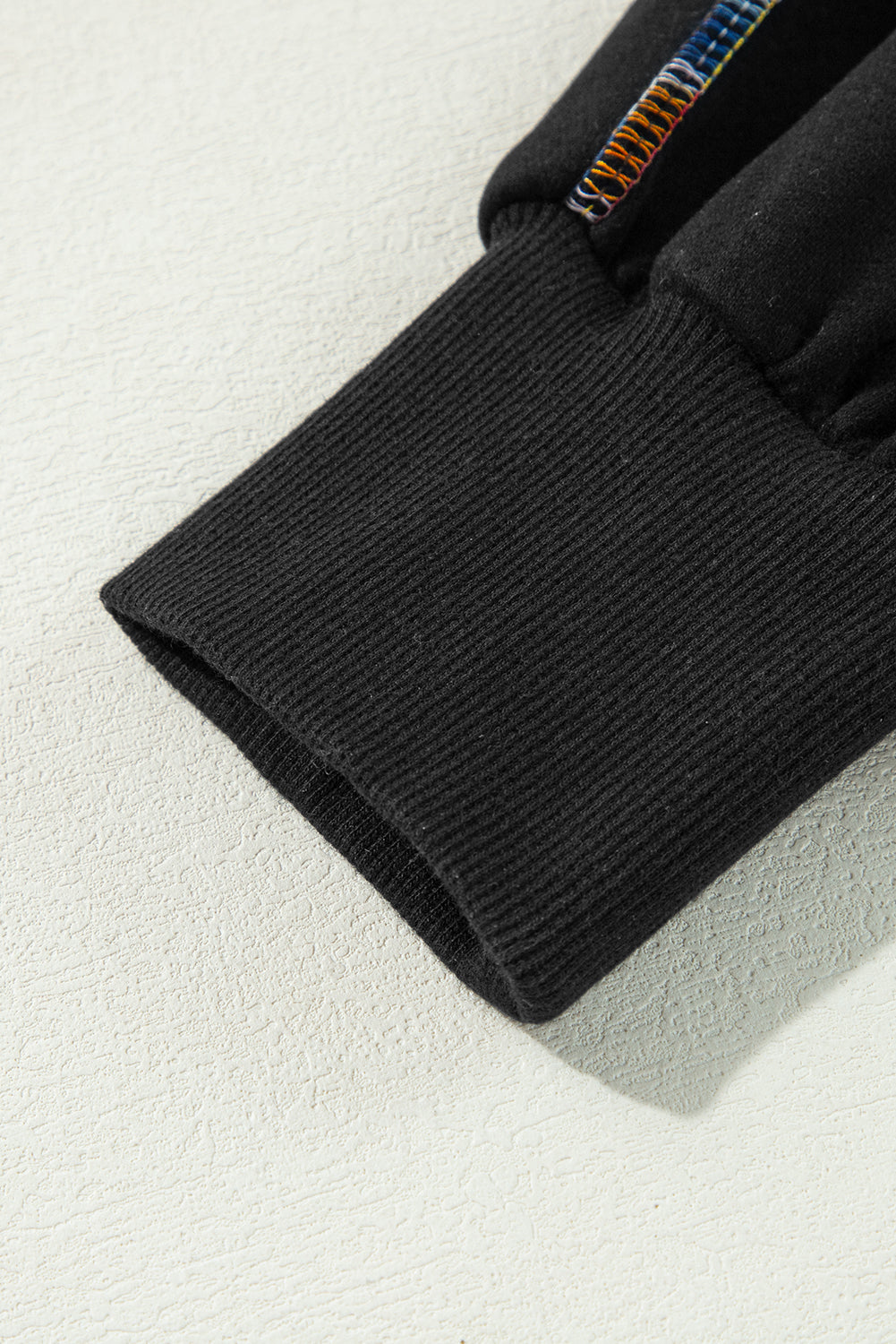 Schwarzes Pullover-Sweatshirt mit überschnittener Schulter und kontrastierendem Regenbogenbesatz