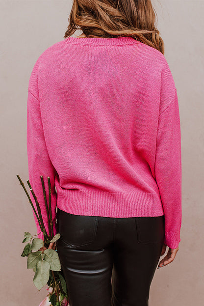 Rippstrickpullover mit überschnittener Schulterpartie und Rosenherz-XOXO-Muster