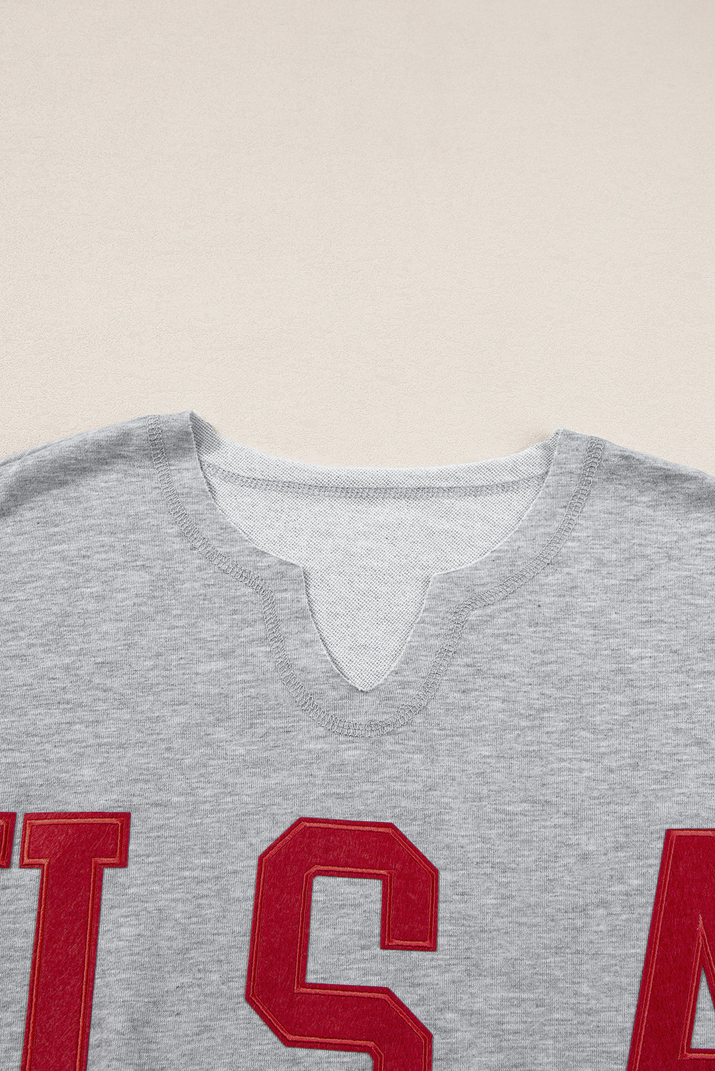 Hellgraues, lockeres T-Shirt mit USA-Schriftzug-Patch und eingekerbtem Ausschnitt