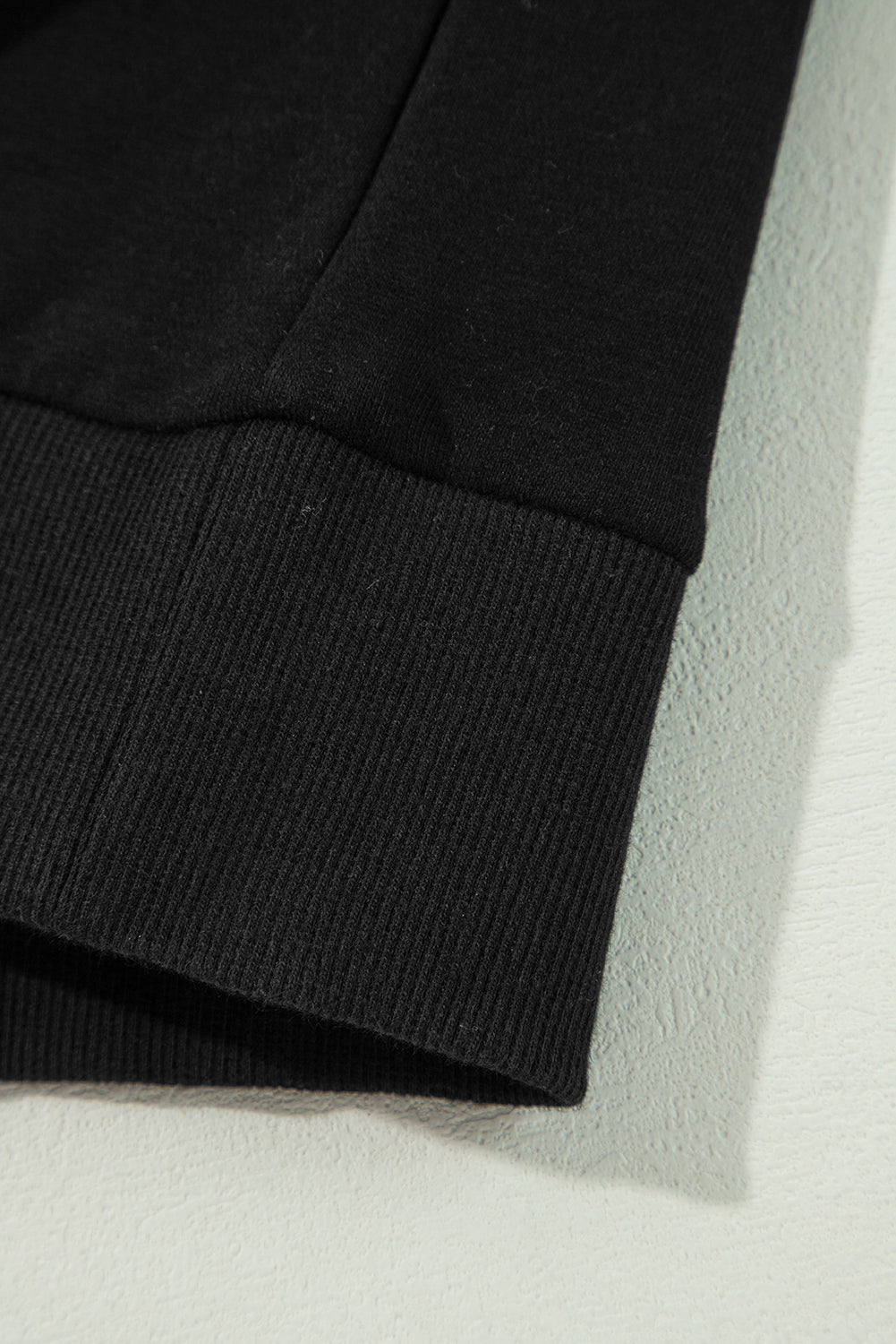 Schwarzes Pullover-Sweatshirt mit überschnittener Schulter und kontrastierendem Regenbogenbesatz