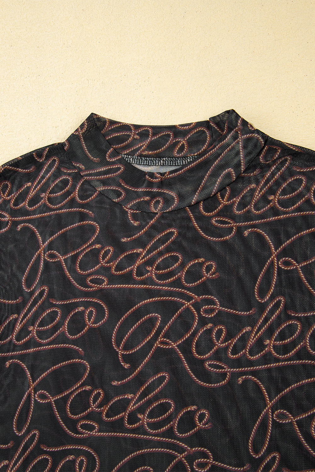 Schwarzes, langärmliges Netzoberteil mit Stehkragen und Western-Rodeo-Print