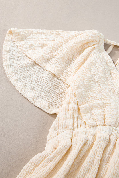 Beiges strukturiertes Minikleid mit tiefem V-Ausschnitt und Cut-Out auf der Rückseite