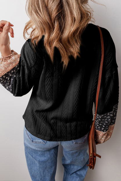 Schwarze Bluse mit V-Ausschnitt und floralem Patchwork-Muster