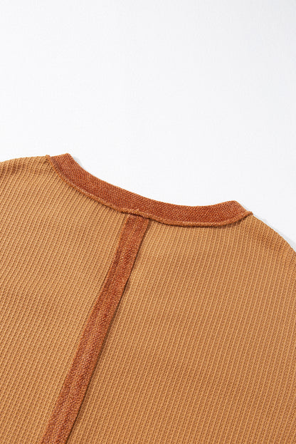 Orangefarbenes Henley-Oberteil aus Waffelstrick mit kontrastierenden Flicken und sichtbaren Nähten