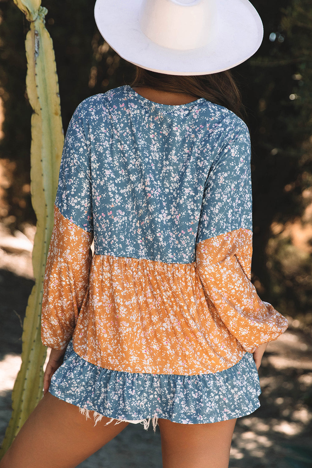 Orangefarbene Bluse mit Blumenmuster, Farbblockdesign, Rüschensaum und Rundhalsausschnitt
