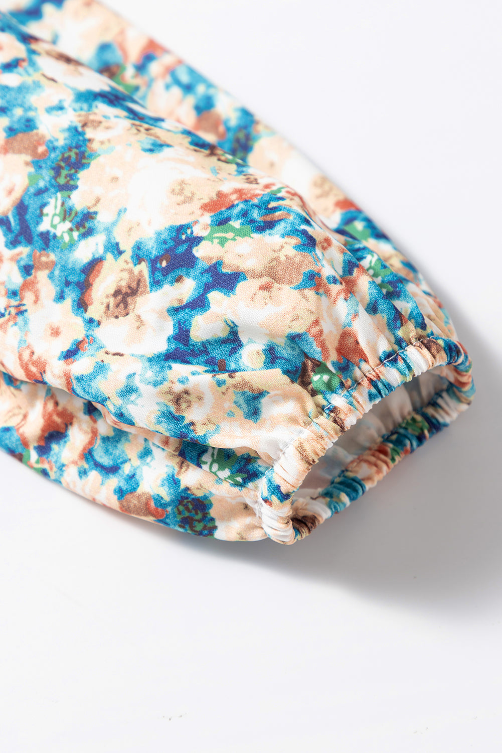 Himmelblaue Bluse mit Blumenmuster, Rüschen und Stehkragen sowie Puffärmeln