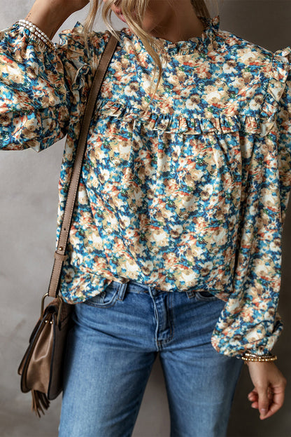 Himmelblaue Bluse mit Blumenmuster, Rüschen und Stehkragen sowie Puffärmeln