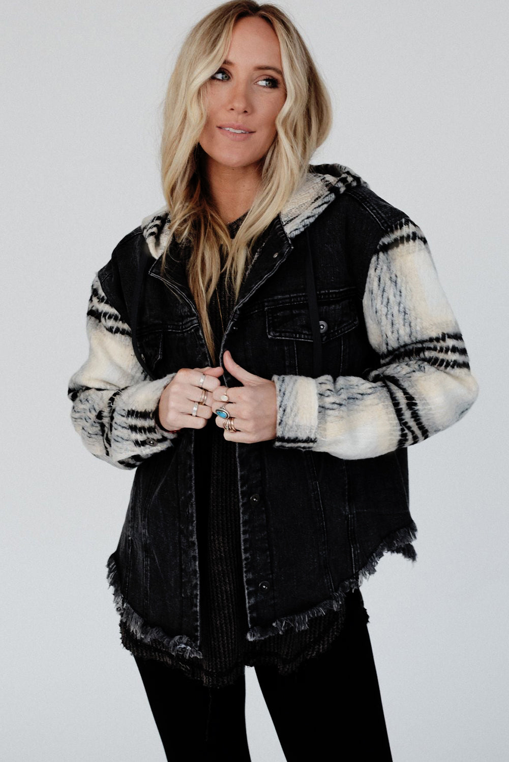 Schwarze Jeansjacke mit Kapuze und karierten Ärmeln und ausgefranstem Saum