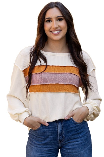 Weißes Stricktop mit Patchwork-Muster und sichtbaren Nähten sowie langen Ärmeln