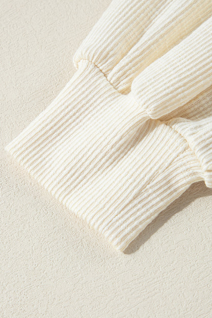 Beiges Pullover-Oberteil aus strukturiertem Strick mit sichtbaren Nähten und V-Ausschnitt