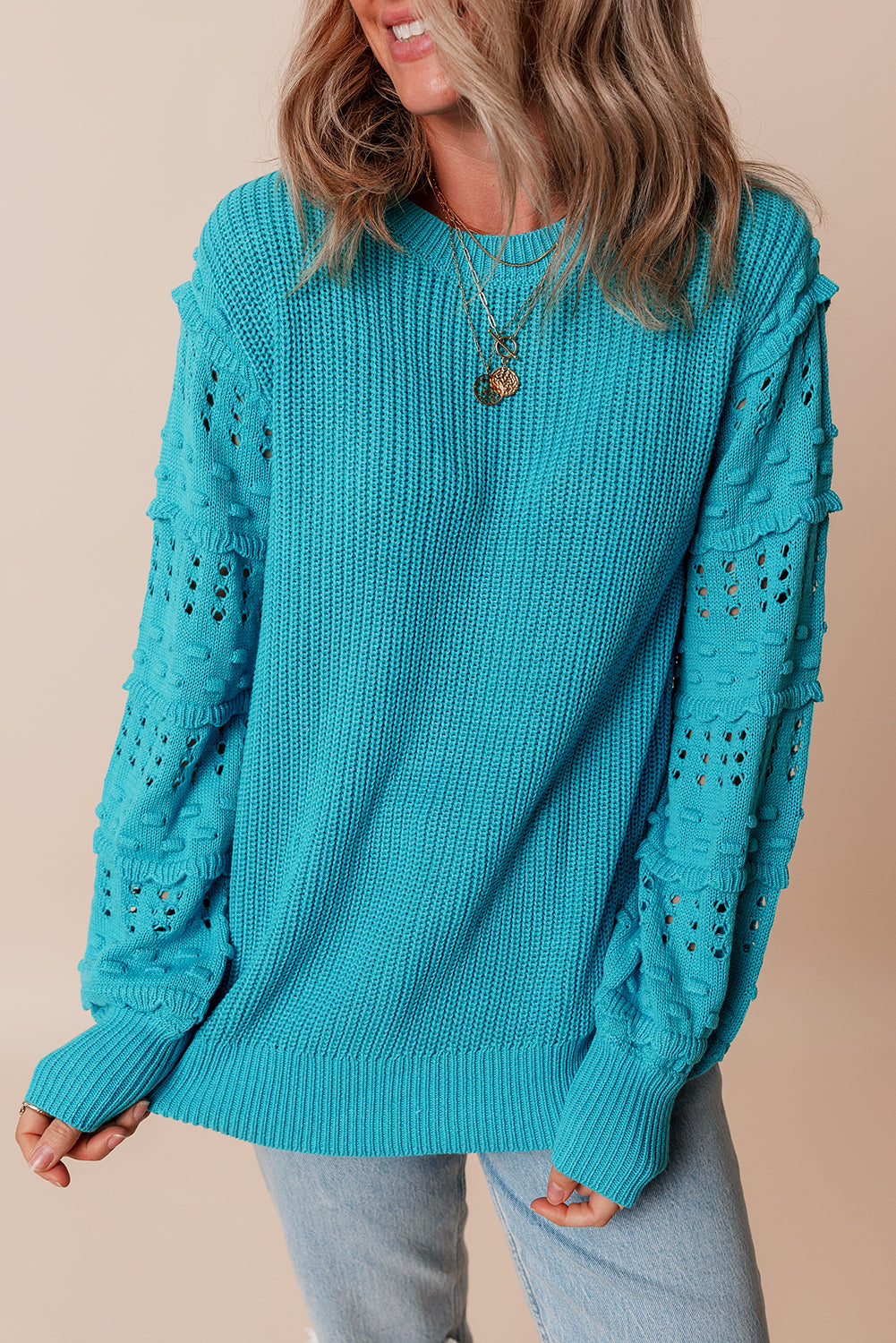 Türkisfarbener Pullover mit gerüschten Ösenärmeln