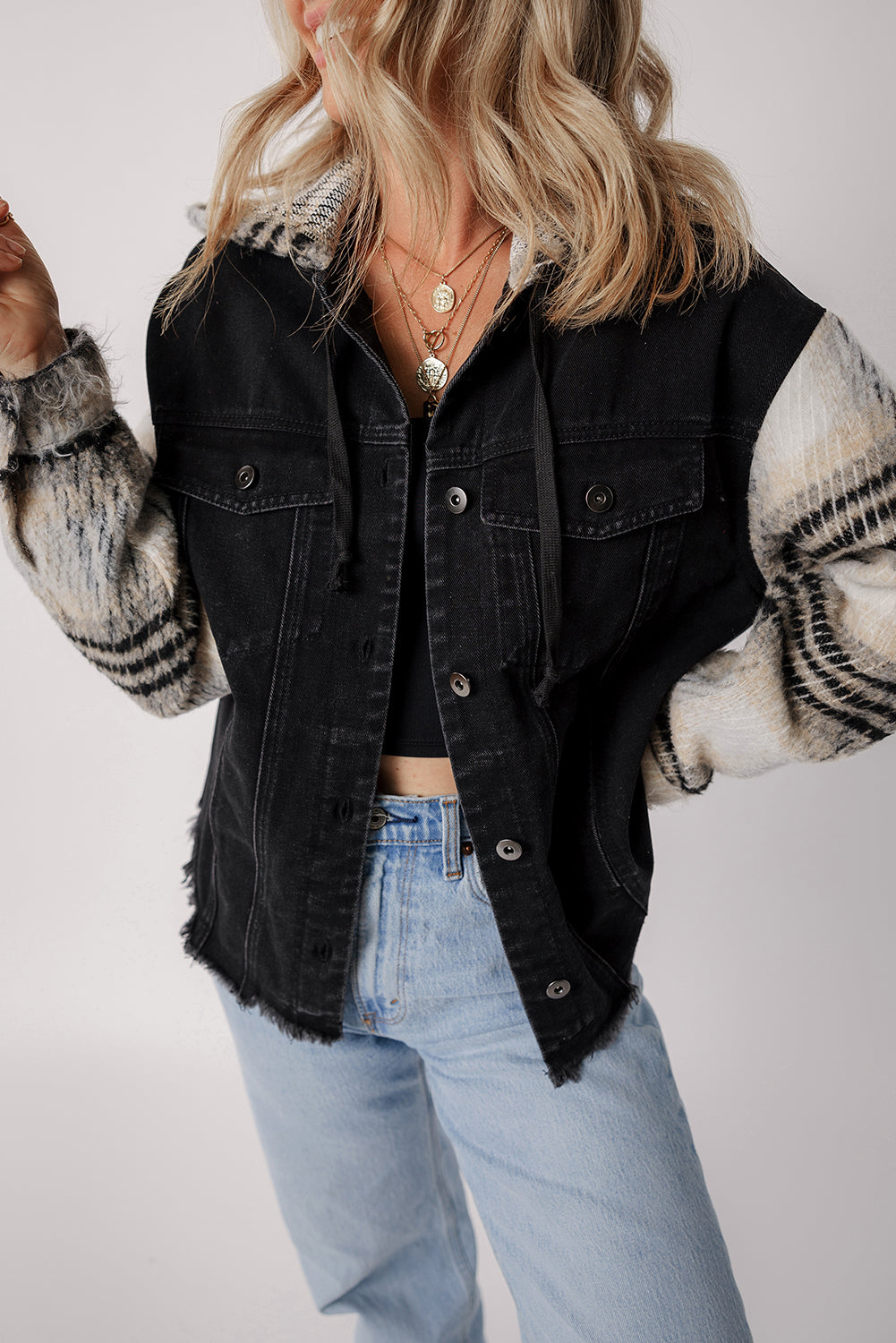 Schwarze Jeansjacke mit Kapuze und karierten Ärmeln und ausgefranstem Saum