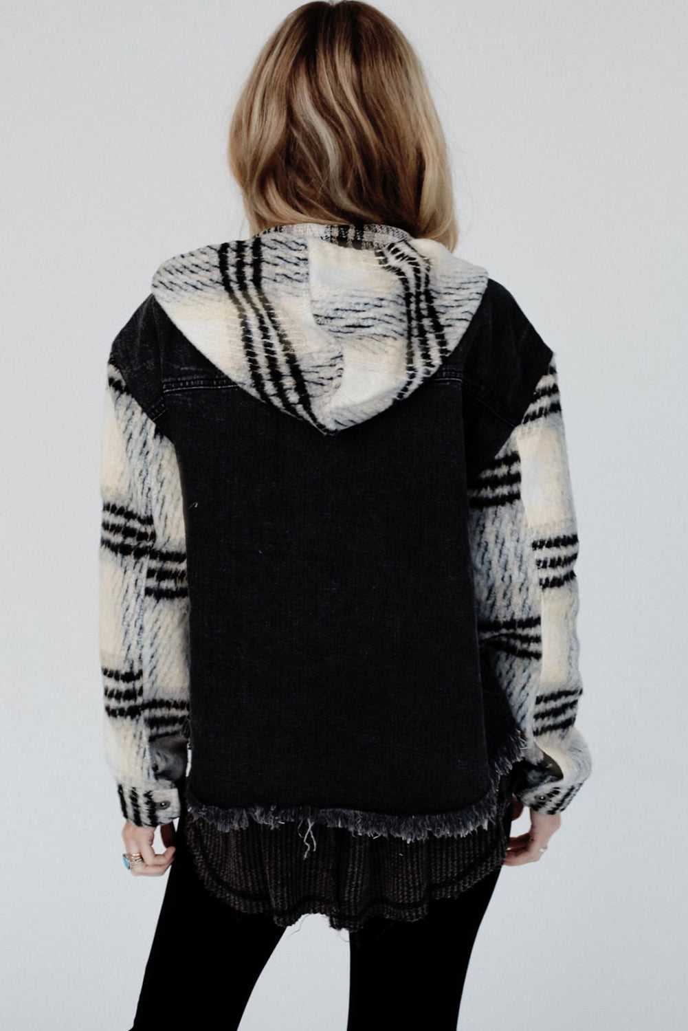 Schwarze Jeansjacke mit Kapuze und karierten Ärmeln und ausgefranstem Saum