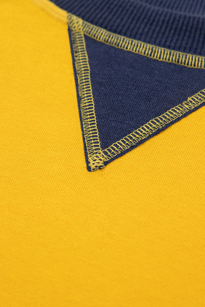 Gelbes Sweatshirt mit Farbblockdesign und Daumenlöchern an den Ärmeln sowie überschnittener Schulter