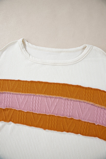 Weißes Stricktop mit Patchwork-Muster und sichtbaren Nähten sowie langen Ärmeln