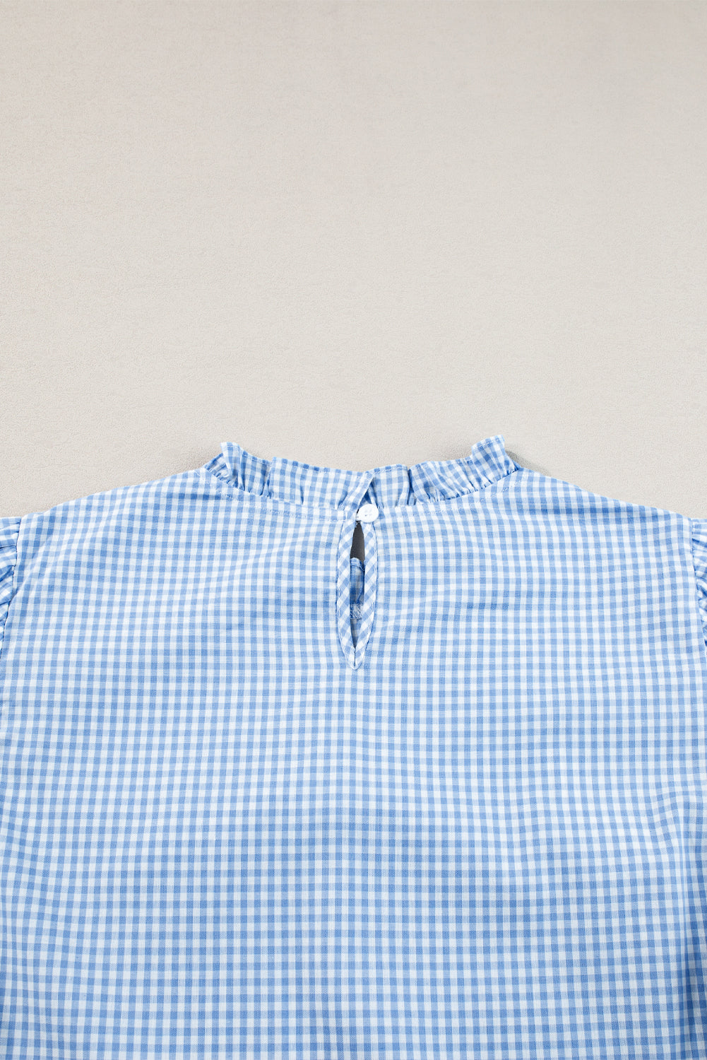 Hellblaue Bluse mit Puffärmeln und Blumenstickerei im Gingham-Stil