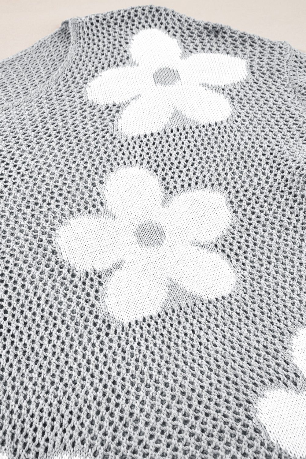 Hellgrauer Strickpullover mit großer Blume und überschnittener Schulter