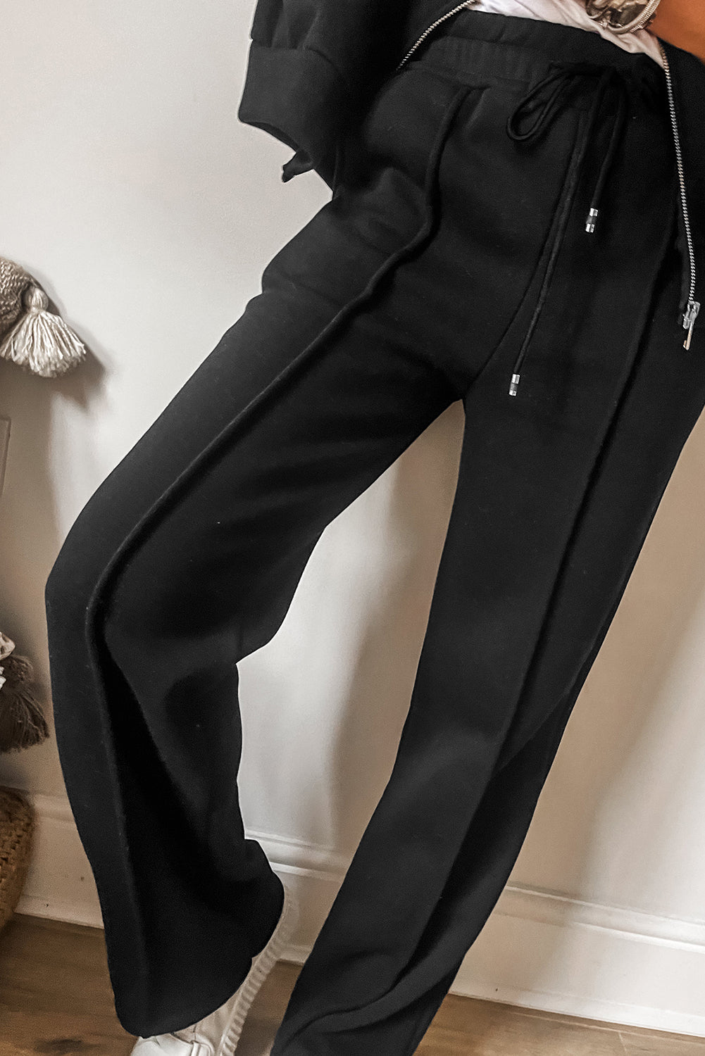 Schwarzes Set mit Jacke mit durchgehenden Nähten und Reißverschluss und Hose mit Kordelzug in der Taille