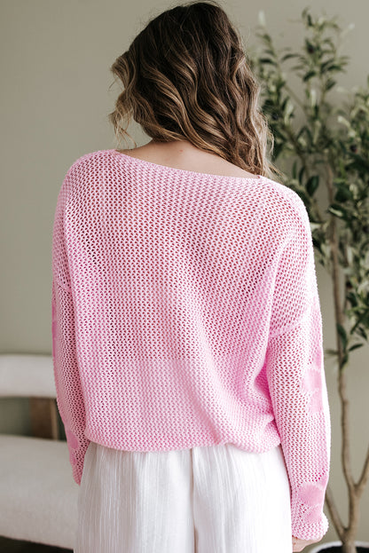 Hellrosa Strickpullover mit großer Blume und tief angesetzter Schulterpartie