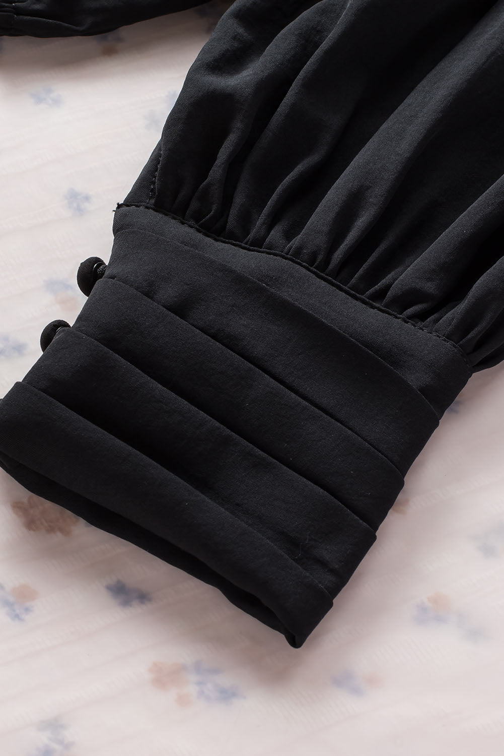 Schwarze, plissierte, lockere Bluse mit gepolsterten Schultern und geknöpften Manschetten