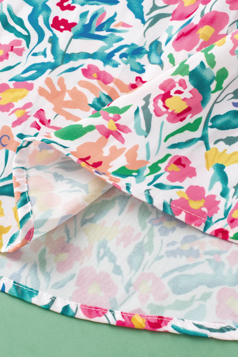 Rosa Bluse mit Blumenmuster, Knöpfen, Schlitz am Ausschnitt und Puffärmeln