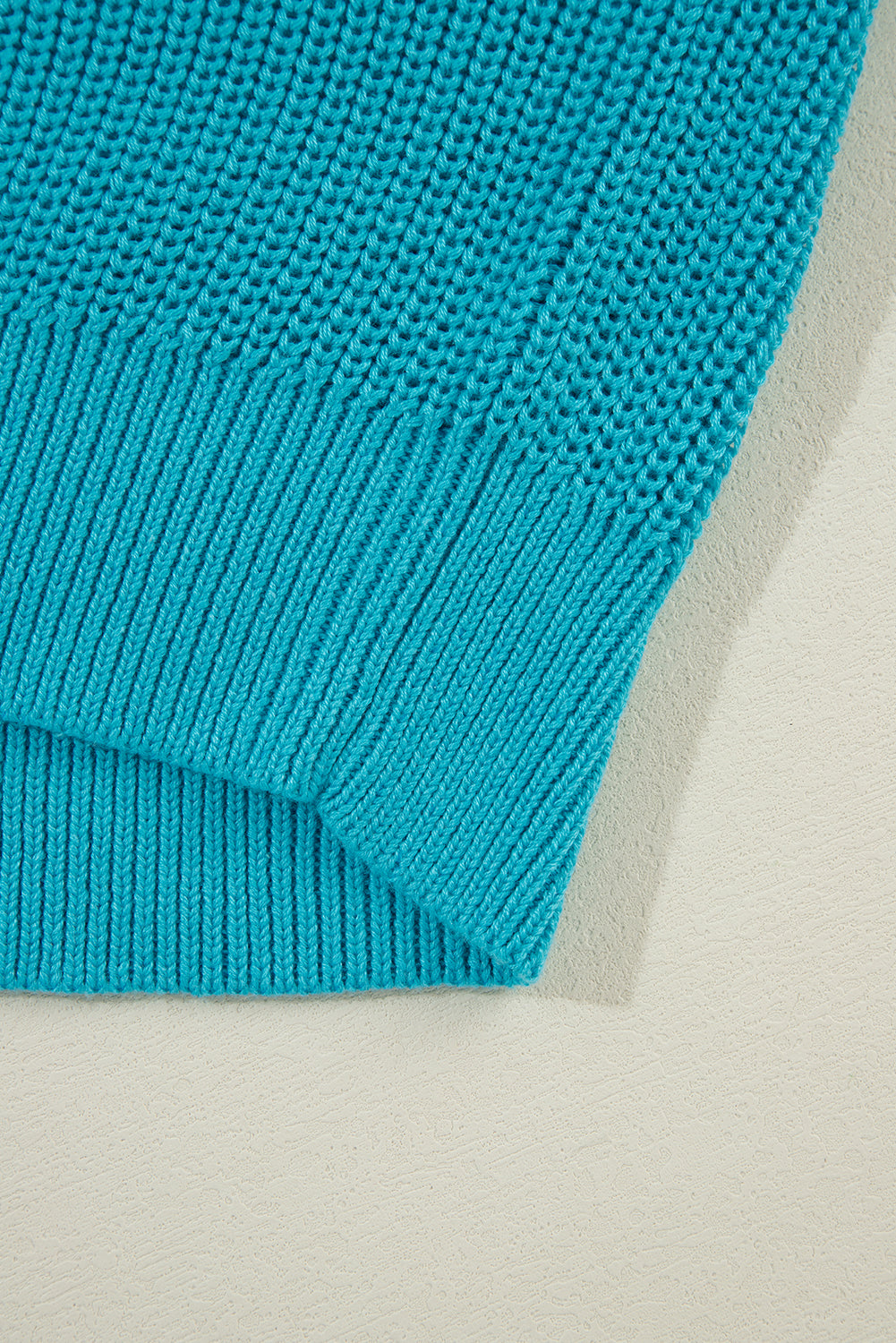 Türkisfarbener Pullover mit gerüschten Ösenärmeln
