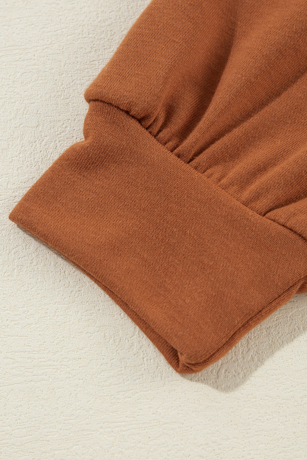 Zimtfarbener Kapuzenpullover mit sichtbaren Nähten und kalter Schulterpartie und Kordelzug